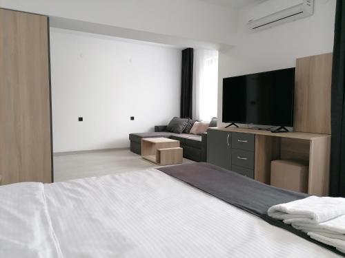 a bedroom with a bed and a couch and a television at гест хаус паркова 33 in Razgrad