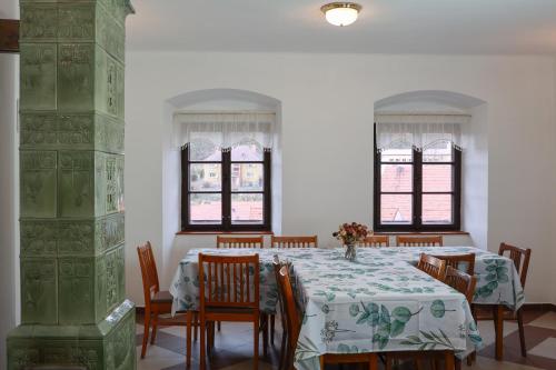 a dining room with a table and chairs and windows at Ubytování U Anděla in Raby