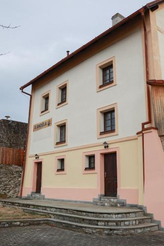 a large white building with stairs in front of it at Ubytování U Anděla in Raby