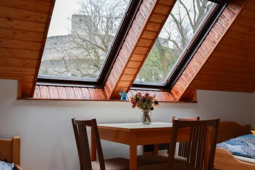a table and chairs in a room with two windows at Ubytování U Anděla in Raby