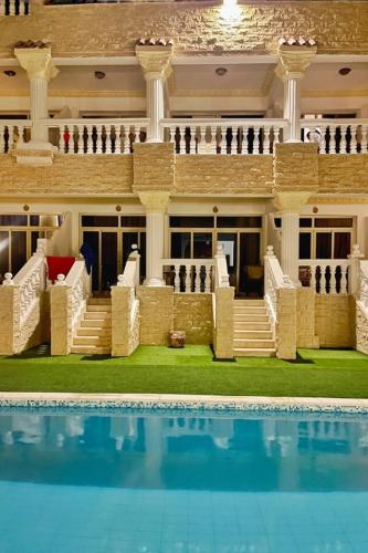 a large house with a swimming pool in front of it at Lucky palace Dahab in Dahab
