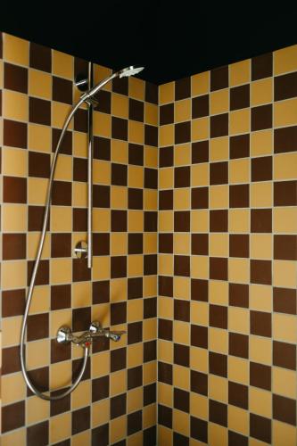 a shower in a bathroom with a checkered wall at JAM Ghent in Ghent