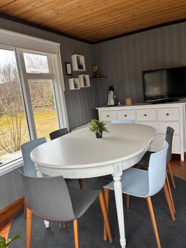 a dining room with a white table and chairs at Eyja Mork - Aurora Igloo with shared Hot Tub, BBQ and kitchen - B2 in Stora Mork