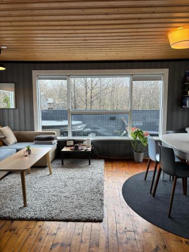 a living room with a couch and a table at Eyja Mork - Aurora Igloo with shared Hot Tub, BBQ and kitchen - B2 in Stora Mork