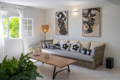 una sala de estar con un sofá y una mesa en Bel Embrun - Villa Iléenne, en Les Trois-Îlets