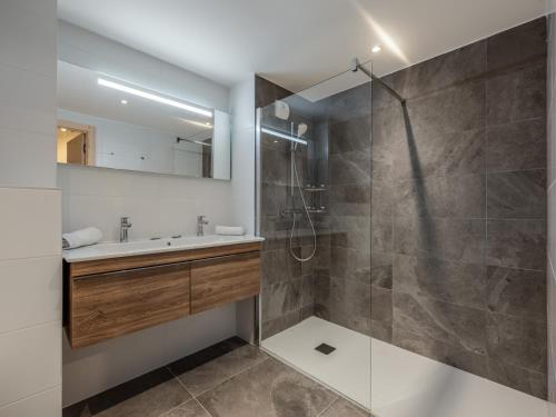 une salle de bain avec une douche, un lavabo et un miroir dans l'établissement Apt Alchimie B11 - Châtel BO Immobilier, à Châtel