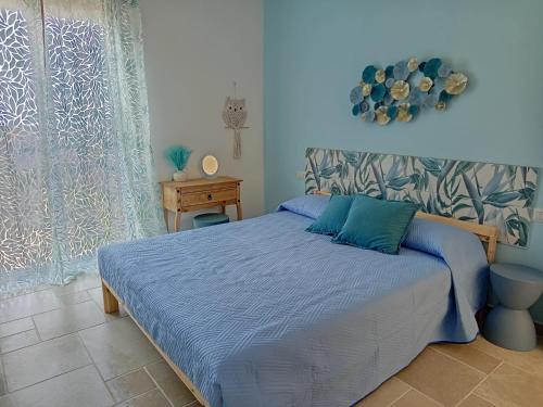 a bedroom with a bed with a blue comforter at Le tre civette in Agropoli