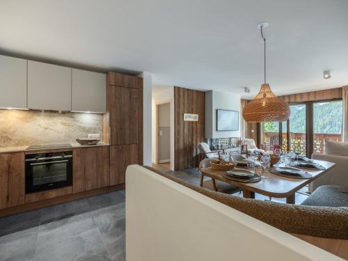 une cuisine et un salon avec une table et un canapé dans l'établissement Apt Alchimie B11 - Châtel BO Immobilier, à Châtel