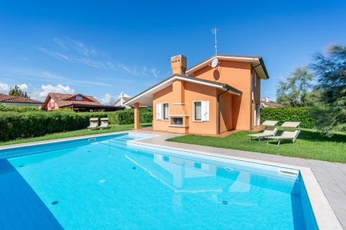 a villa with a swimming pool and a house at Isola di Albarella in Isola Albarella