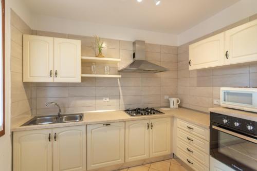 a kitchen with white cabinets and a sink at Isola di Albarella in Isola Albarella