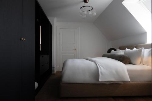 a bedroom with a bed with white sheets and pillows at Park Lane Copenhagen in Hellerup