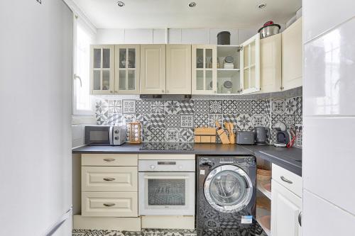 une cuisine avec une machine à laver et un lave-linge dans l'établissement Maison sur les quais de Seine proche de Paris, à Villeneuve-la-Garenne