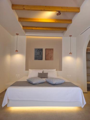 a bedroom with a white bed with two pillows at Moonlight Apartments & Suites in Fira