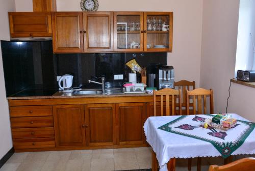 a kitchen with wooden cabinets and a table with a table sidx sidx sidx at Domek na wzgórzu in Łapsze Niżne