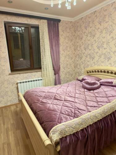 a bedroom with a purple bed with a window at Dream house in Yeghegnadzor