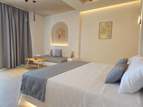 a bedroom with a large bed and a couch at Moonlight Apartments & Suites in Fira