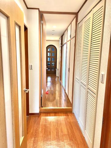 an empty hallway with wood floors and white doors at マリーナベイCentral in Atami