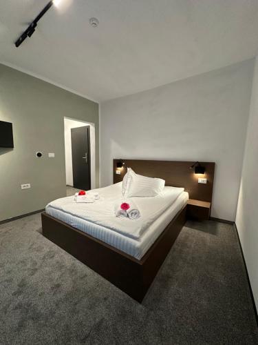 a bedroom with a bed with two roses on it at Hotel Angelo Boutique in Prăjila