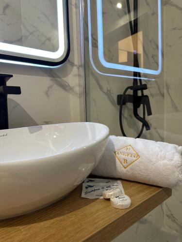 baño con lavabo y papel higiénico en Hotel Angelo Boutique, en Prăjila