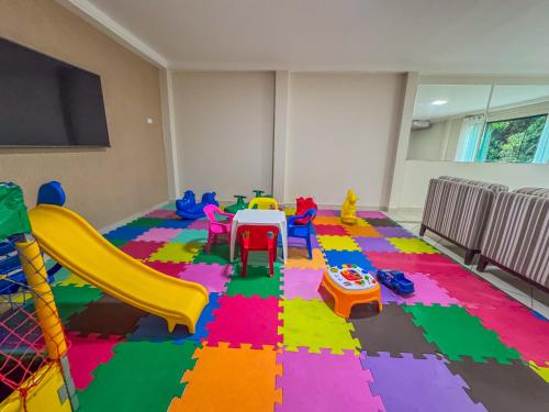 a room with a table and chairs and a slide at Hotel Nacional Inn Guarujá in Guarujá