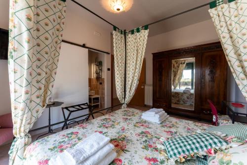 a bedroom with a bed and a window with curtains at Tenuta Tre Gemme in Cantina- Renascenzia SantIrene in Catignano