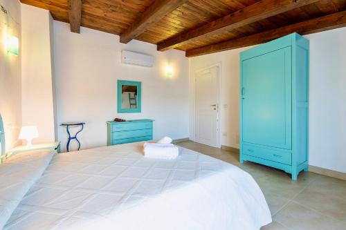 a bedroom with a large bed with a blue cabinet at Villa in Alghero just 5 minutes from the historical center in Casa Linari
