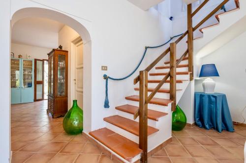 a staircase in a living room with green vases at Villa in Alghero just 5 minutes from the historical center in Casa Linari