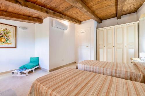 a bedroom with two beds and a chair at Villa in Alghero just 5 minutes from the historical center in Casa Linari