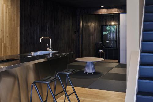 a kitchen with a sink and a table with stools at Alchemy 0 in Osaka