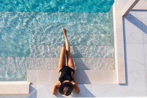 a person laying on the floor next to a swimming pool at Anelia Villa in Chania Town