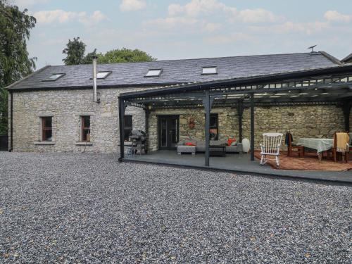 an external view of a stone house with a patio at Woodville Lodge in Ród