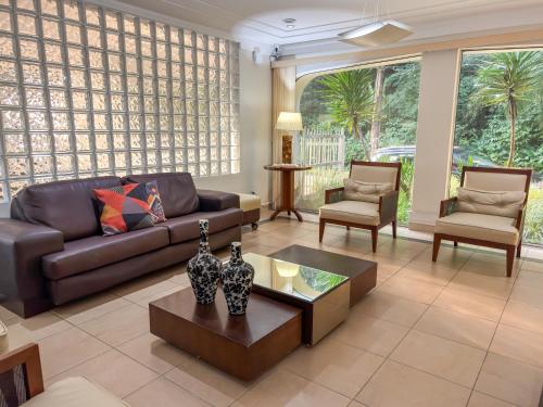 a living room with a couch and a table and chairs at Hotel Nacional Inn Guarujá in Guarujá