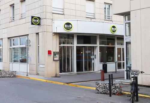 a store front of a building with a bike parked outside at B&B HOTEL Reims Centre Erlon in Reims