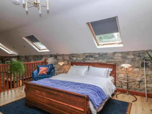 a bedroom with a bed and a stone wall at Woodville Lodge in Ród