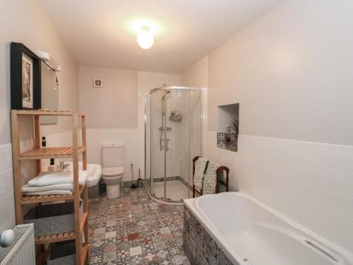 a bathroom with a shower and a tub and a toilet at Woodville Lodge in Ród