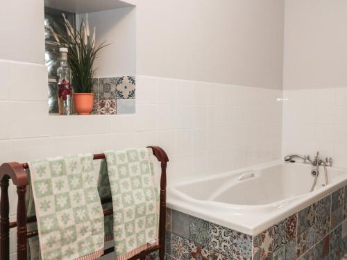 a bathroom with a tub and a sink at Woodville Lodge in Ród