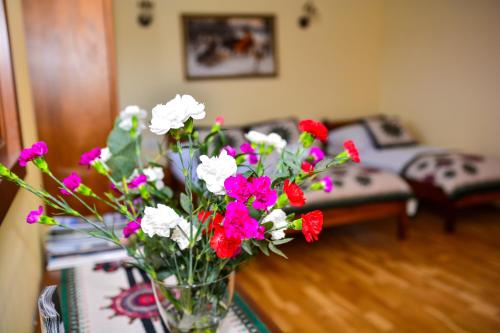 a vase of flowers on a table in a living room at Domek na wzgórzu in Łapsze Niżne