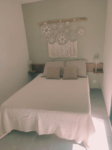 un dormitorio con una cama grande blanca con almohadas en Charmante maisonette, en Porto Vecchio
