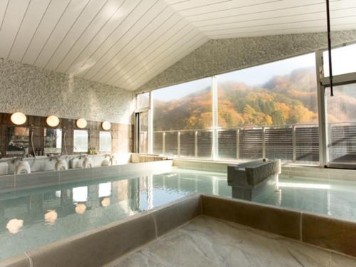 a large swimming pool with a view of a mountain at LiVEMAX RESORT Kawaji in Nikko