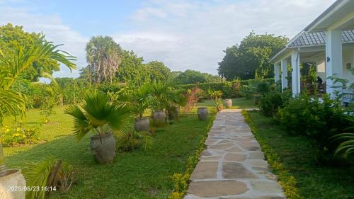 a walkway in front of a house with palm trees at Shalom Wellspring Homestay in Malindi