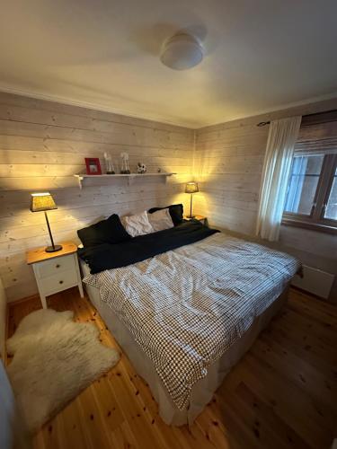 a bedroom with a bed with two lamps and a window at Ski in-ski out leilighet Hemsedal in Fausko