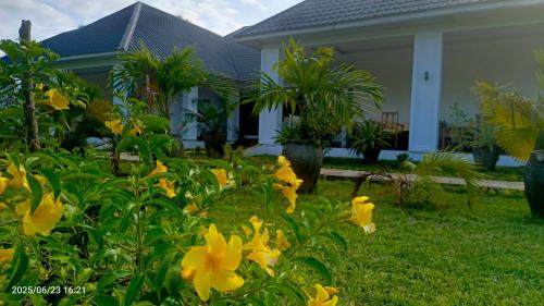 a house with yellow flowers in the yard at Shalom Wellspring Homestay in Malindi