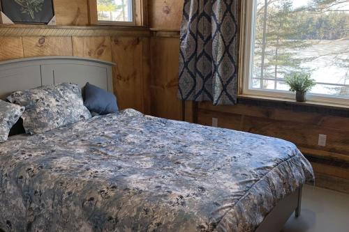 a bedroom with a bed and a window at Hunt Acres Grey Cottage in Newcastle