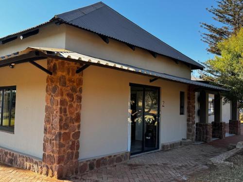 a small building with a black roof at Welgedacht Lodge in Cullinan
