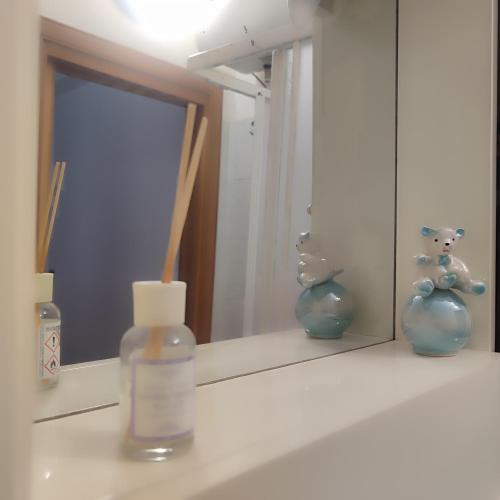 a mirror with two vases and a candle on a shelf at Casa Camella in Perdifumo