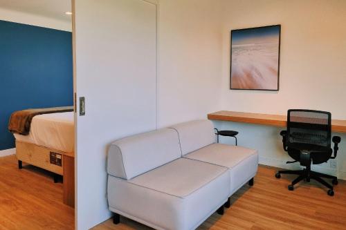 a hospital room with a couch and a desk at Atrium Studios by Xtay – Estúdios modernos, bem localizados e a 9min da Arena Opus in Palhoça