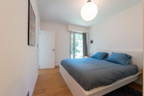a bedroom with a bed with blue pillows at Villa Piscine Entre Lac et Océan in Soorts-Hossegor