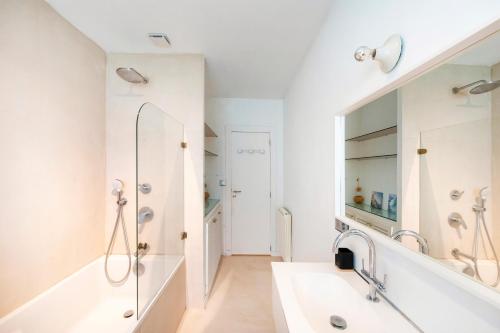 a white bathroom with a sink and a mirror at Villa Piscine Entre Lac et Océan in Soorts-Hossegor