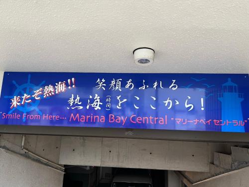 a sign in an airport with asian writing on it at マリーナベイCentral in Atami