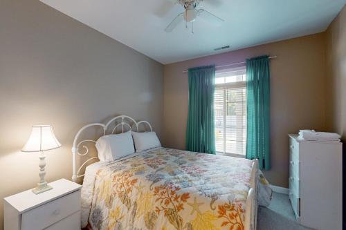 a bedroom with a bed and a window with green curtains at Summerlyn --- 34297 Summerlyn Dr, Apt 501 in Lewes